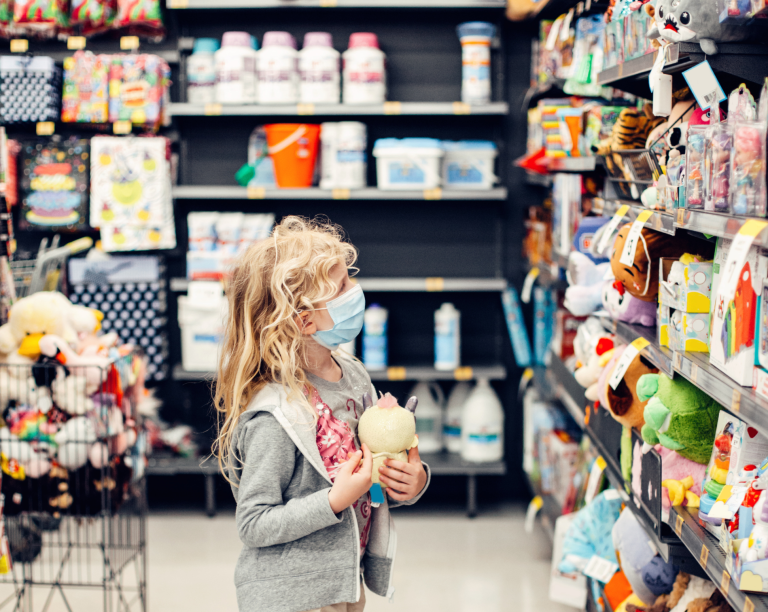Child browsing toys at eye level in a retail store